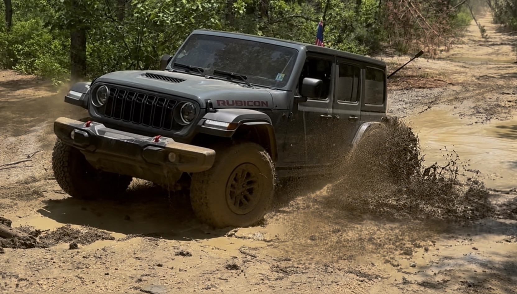 Rock Rhino, a 2026 Jeep Wrangler Rubicon Extreme Recon in Anvil, blasting through a mud hole on the trail